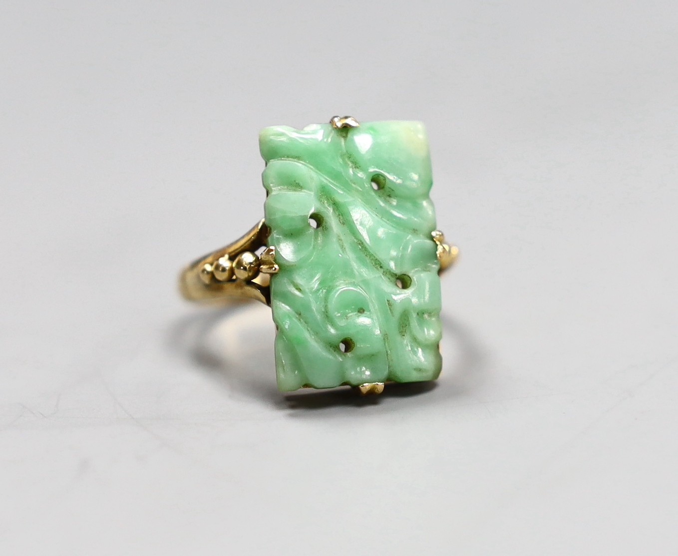 An early 20th century yellow metal Chinese jade plaque ring, size M, gross 4.8 grams